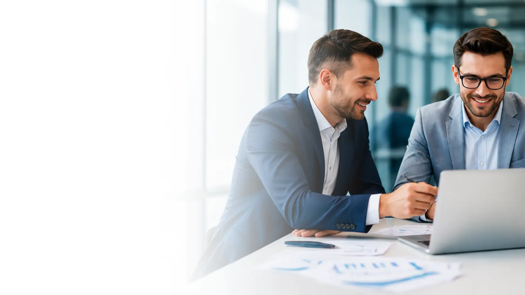 Two company directors reviewing their accounts on a laptop in a bright office