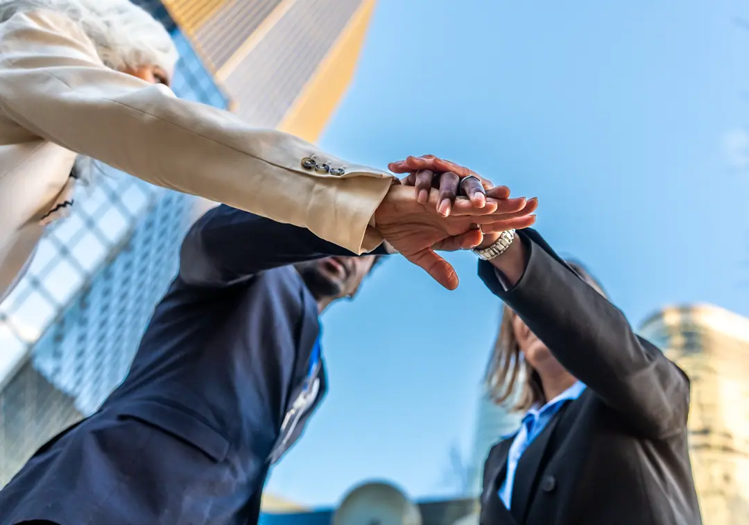 A team stacking hands together in celebration